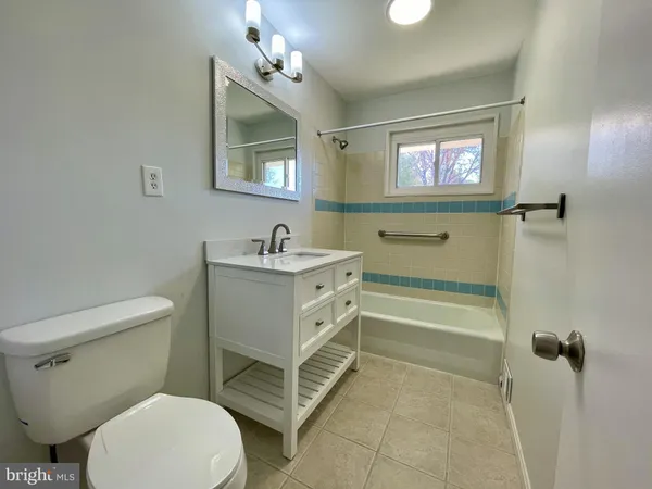 a bathroom with a sink a toilet a mirror and shower