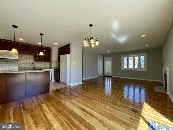 a view of kitchen with granite countertop sink and refrigerator