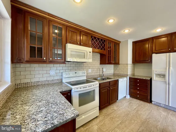 a kitchen with stainless steel appliances granite countertop a stove sink and cabinets