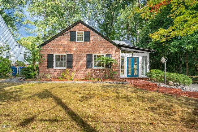 a front view of a house with a garden and yard