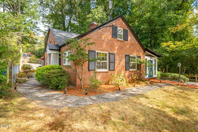 a front view of a house with a yard and potted plants