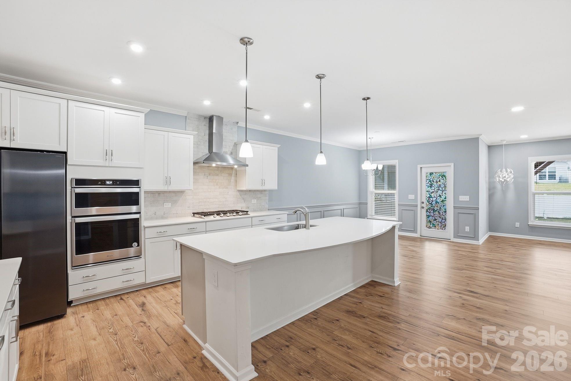 4029 Spring Garden Street Fort Mill, SC 29715 - Photo 17 of 48 a large kitchen with stainless steel appliances kitchen island a large counter top and a wooden floors
