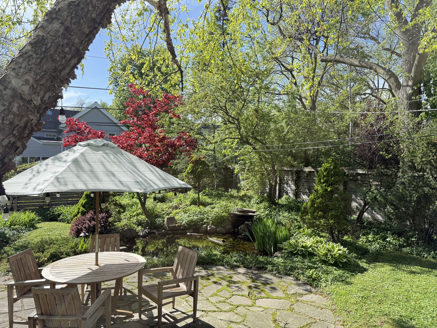 712 Juniper Road Glenview, IL 60025 - Photo 2 of 6 a backyard of a house with table and chairs under an umbrella