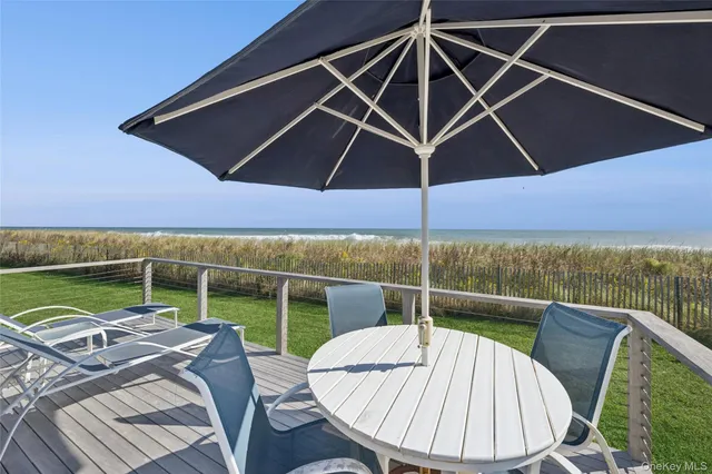 a view of a roof deck with couches under an umbrella