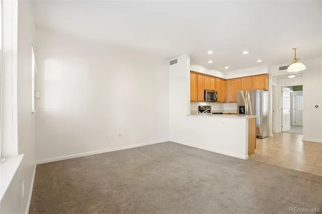 a view of a kitchen with refrigerator and a sink
