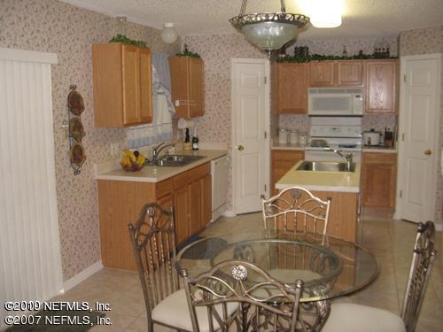 3411 Hickory Hammock Road Jacksonville, FL 32226 - Photo 10 of 14 a kitchen with a table chairs stove and refrigerator