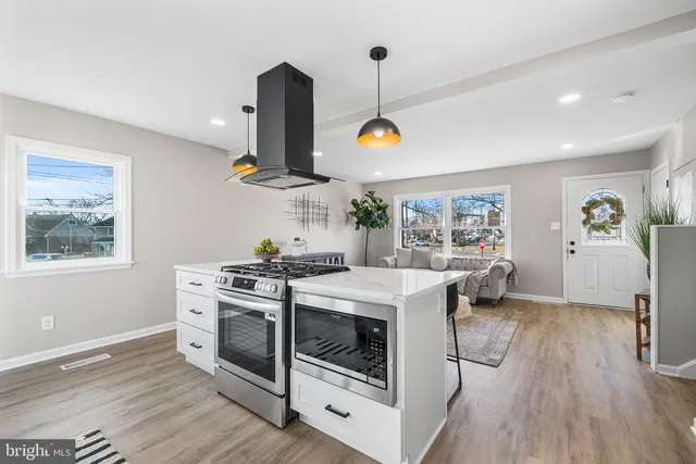 a kitchen with stainless steel appliances granite countertop a stove and a wooden floors