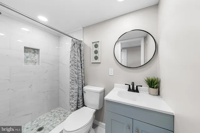 a bathroom with a sink a toilet and a mirror