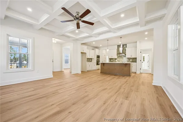 a kitchen with stainless steel appliances kitchen island granite countertop a sink a stove and a wooden floors