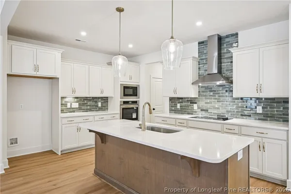 a view of front door with hallway and wooden floor