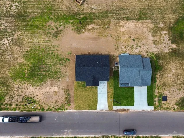 aerial view of a house with a yard and large tree