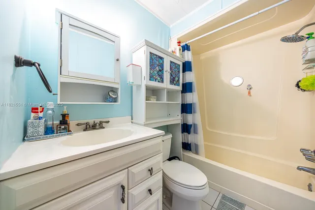 a large bedroom with a bed and a mirror on the dresser