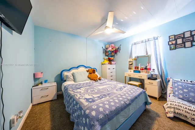 a bedroom with a bed and a flat tv screen on dresser
