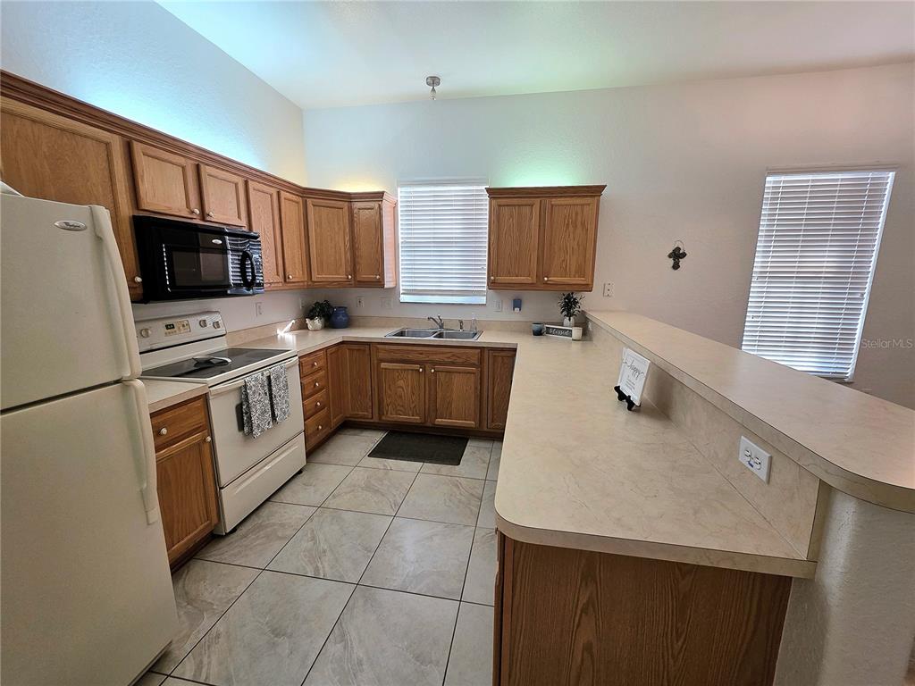2116 Northeast 40th Terrace Ocala, FL 34470 - Photo 2 of 37 a kitchen with a sink a stove top oven and white kitchen