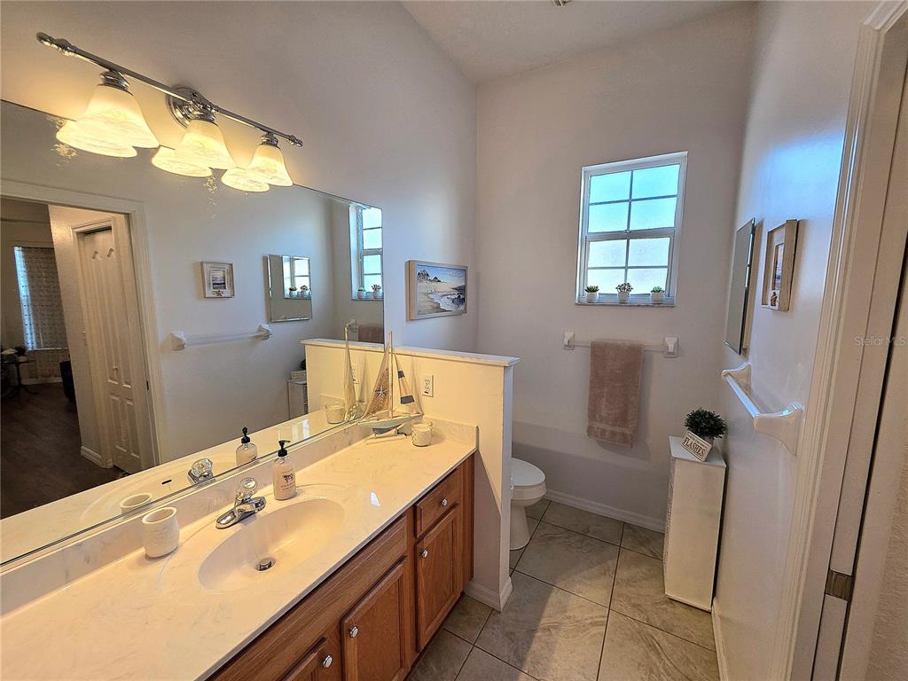 2116 Northeast 40th Terrace Ocala, FL 34470 - Photo 22 of 37 a bathroom with a sink mirror vanity and toilet