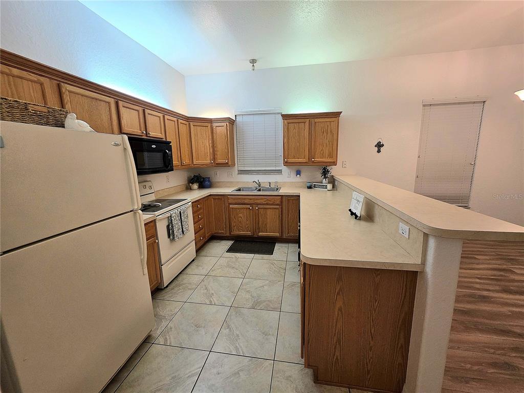 2116 Northeast 40th Terrace Ocala, FL 34470 - Photo 8 of 37 a kitchen with a sink a refrigerator and cabinets