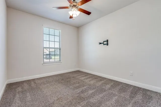 an empty room with a window and a fan
