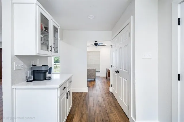 a view of a house with floor to ceiling windows and a tree