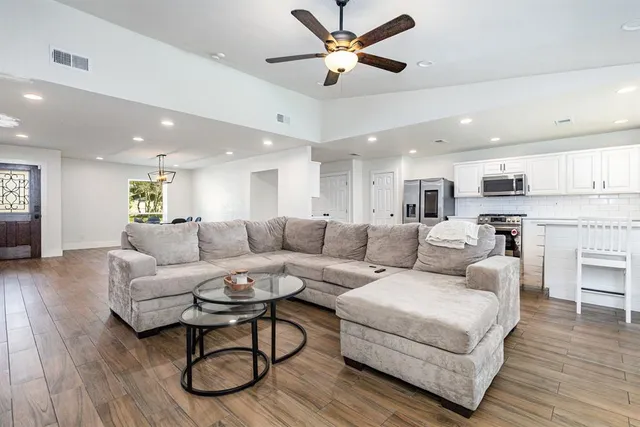a living room with furniture and a wooden floor