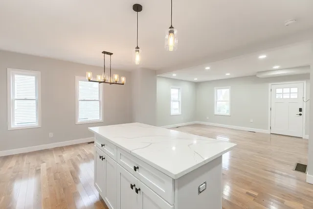 a view of a kitchen and a sink wooden floor and windows