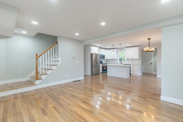 a view of kitchen living space with refrigerator sink and cabinets