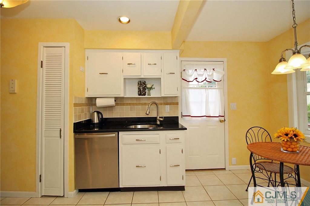 5 Delmar Place Edison, NJ 08837 - Photo 14 of 25 a kitchen with granite countertop a sink a stove a refrigerator and cabinets
