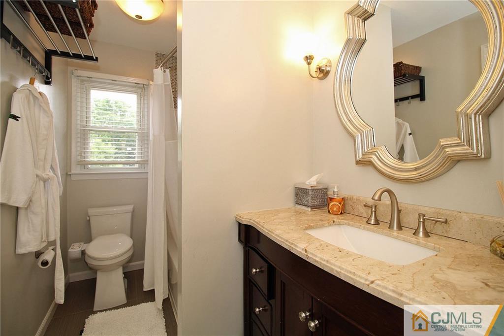 5 Delmar Place Edison, NJ 08837 - Photo 19 of 25 a bathroom with a granite countertop sink a toilet and a mirror