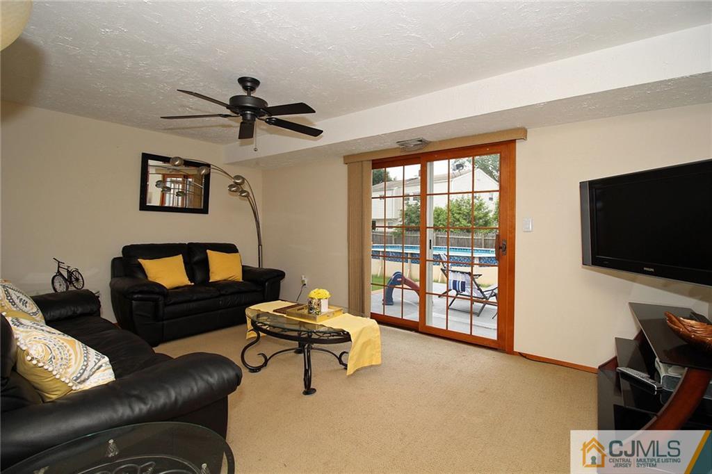 5 Delmar Place Edison, NJ 08837 - Photo 20 of 25 a living room with furniture a flat screen tv and a large window