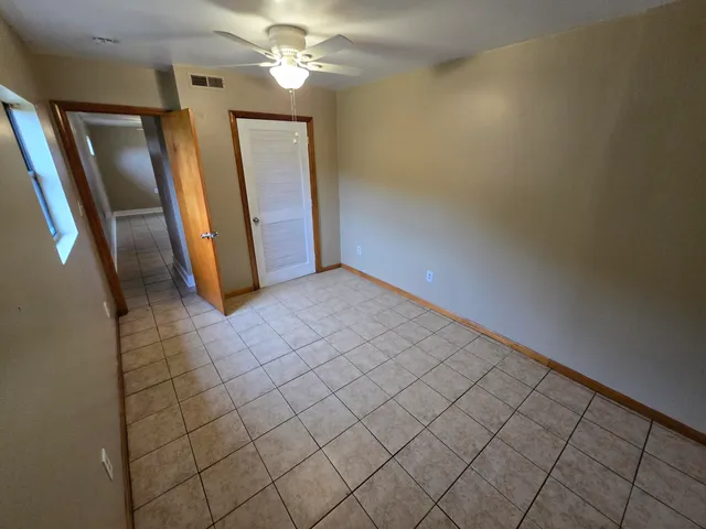 an empty room with wooden floor and staircase