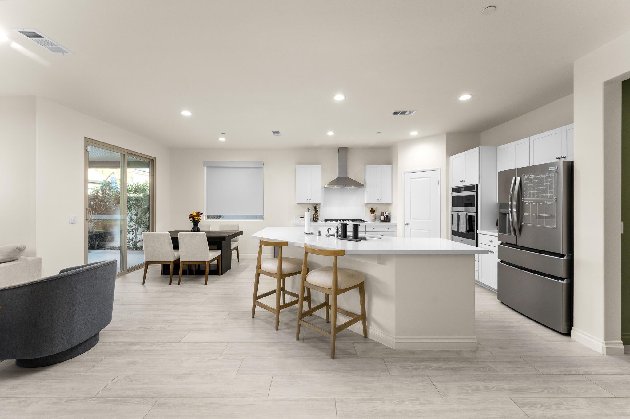 84458 Calle Larriva Coachella, CA 92236 - Photo 15 of 43 a kitchen with stainless steel appliances a sink a stove a refrigerator cabinets and chairs