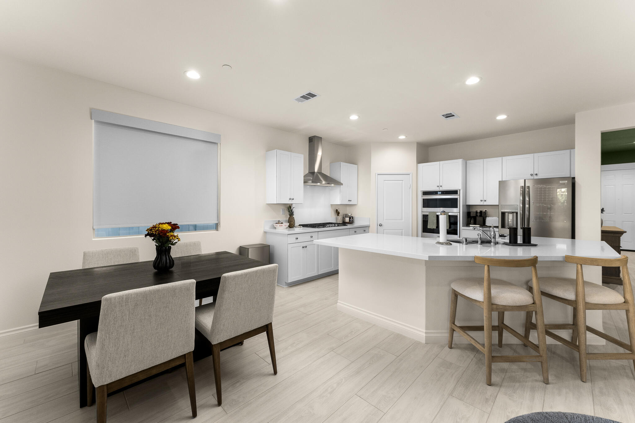 84458 Calle Larriva Coachella, CA 92236 - Photo 20 of 43 a kitchen with a dining table chairs refrigerator and cabinets