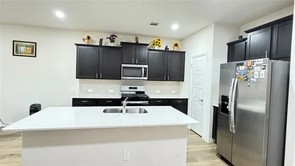 a kitchen with stainless steel appliances a refrigerator sink and microwave