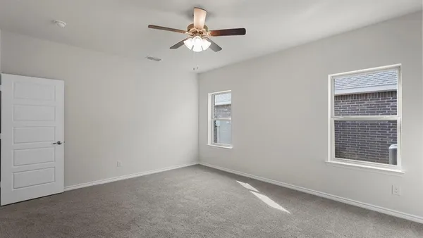 an empty room with a window and a fan