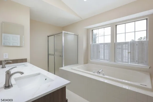 a bathroom with a tub sink mirror and a toilet