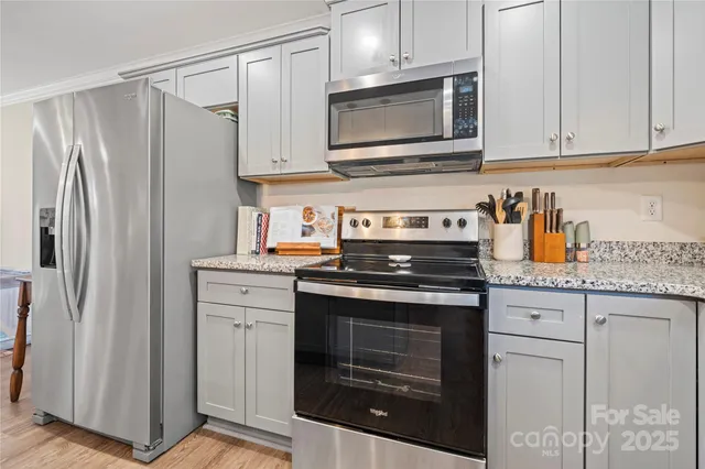 a kitchen with stainless steel appliances granite countertop a stove microwave and refrigerator