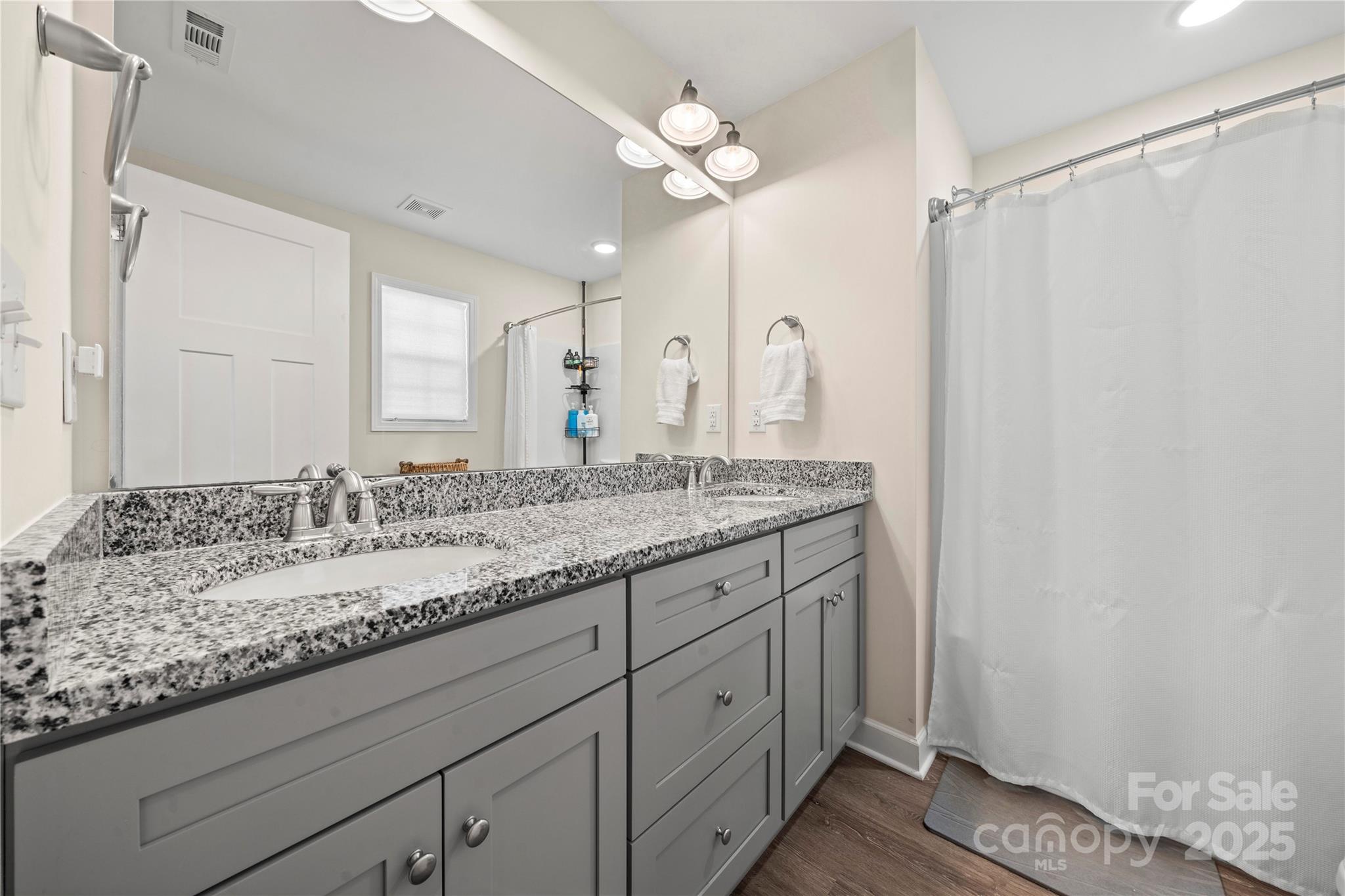 131 Lowry Row, Unit 8 York, SC 29745 - Photo 19 of 32 a bathroom with a granite countertop sink a mirror and a shower