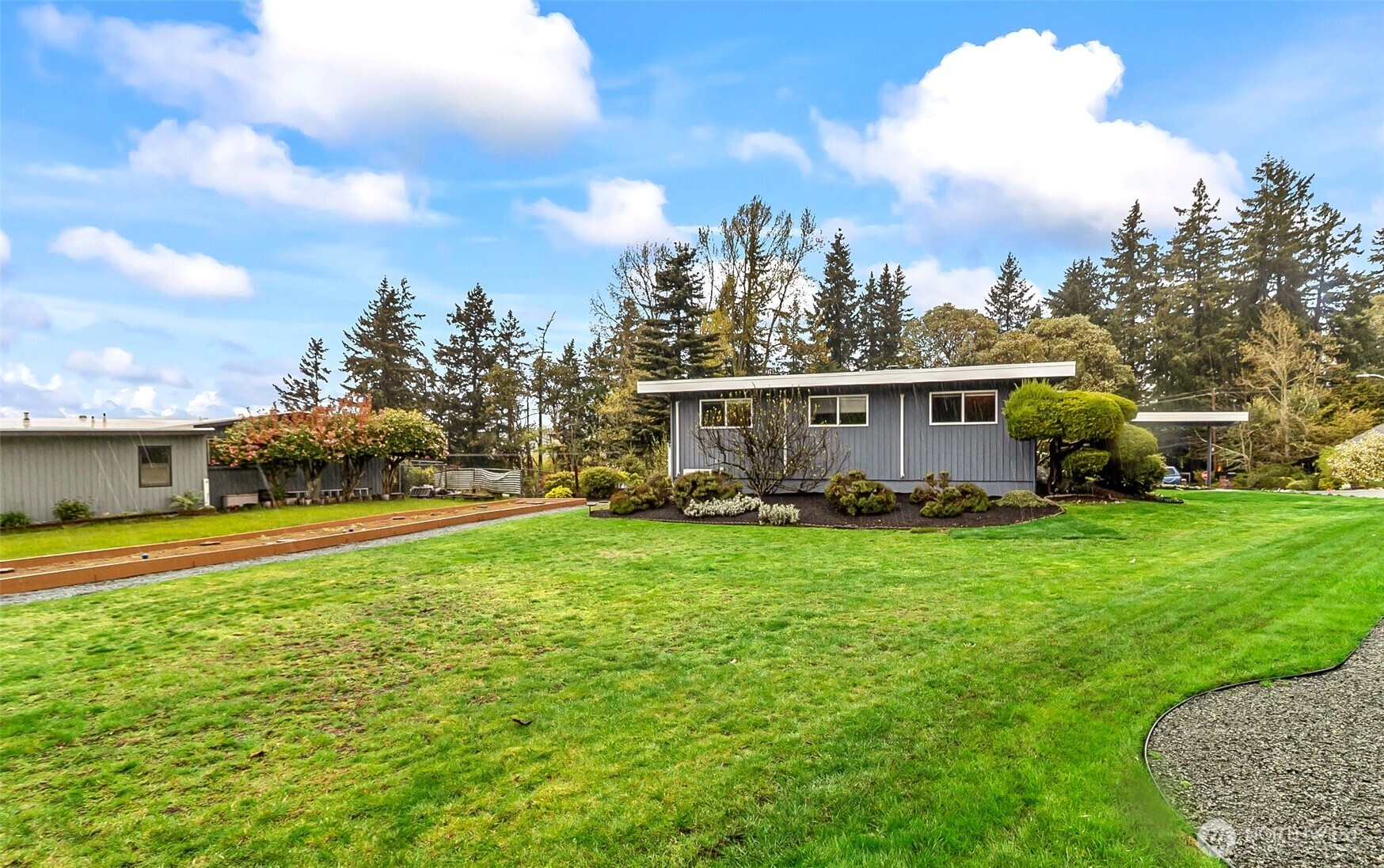 18215 3rd Place Southwest Normandy Park, WA 98166 - Photo 29 of 35 a view of a white house in front of a big yard with plants and large trees