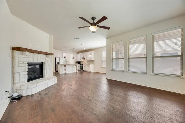an empty room with windows and fireplace