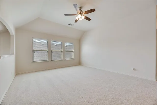 a view of an empty room with ceiling fan