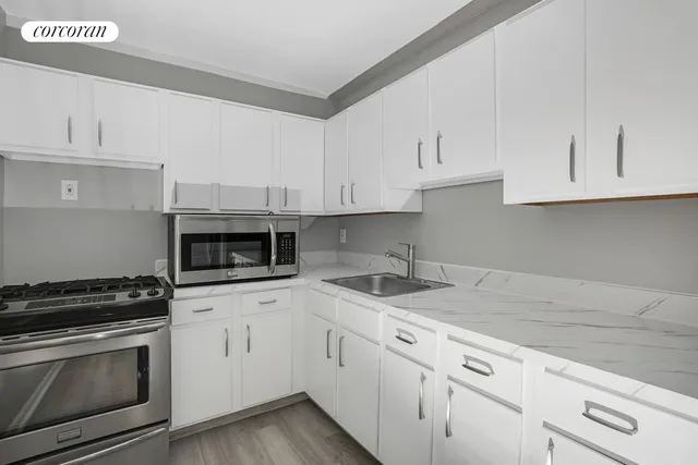 a kitchen with granite countertop white cabinets and stainless steel appliances