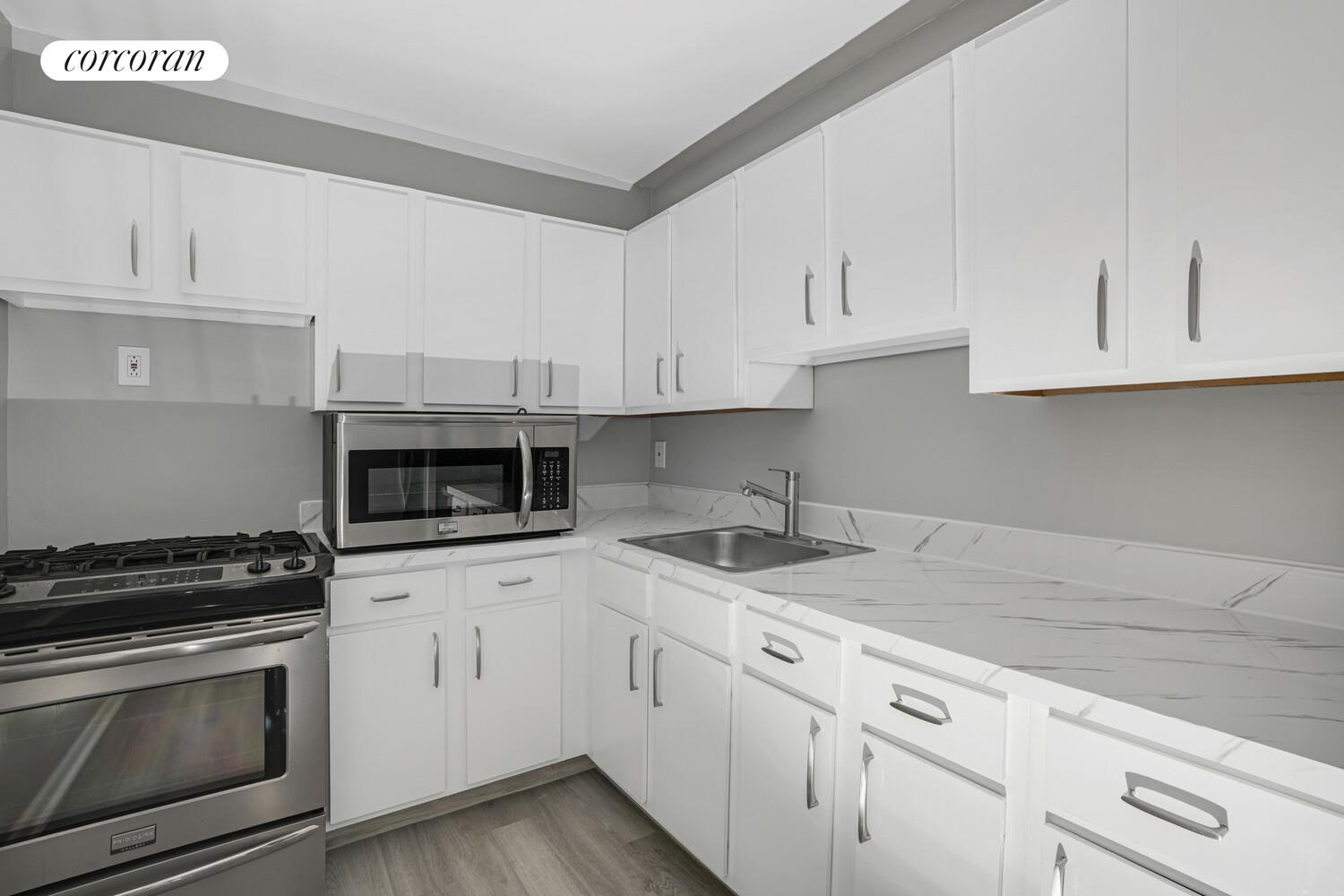 330 Lenox Road, Unit 6S Brooklyn, NY 11226 - Photo 12 of 14 a kitchen with granite countertop white cabinets and stainless steel appliances
