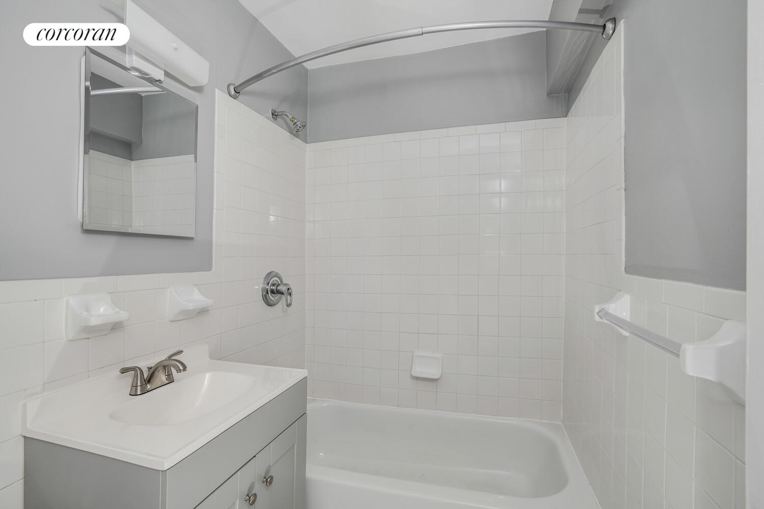 330 Lenox Road, Unit 6S Brooklyn, NY 11226 - Photo 13 of 14 a white bath tub sitting next to a white sink and vanity