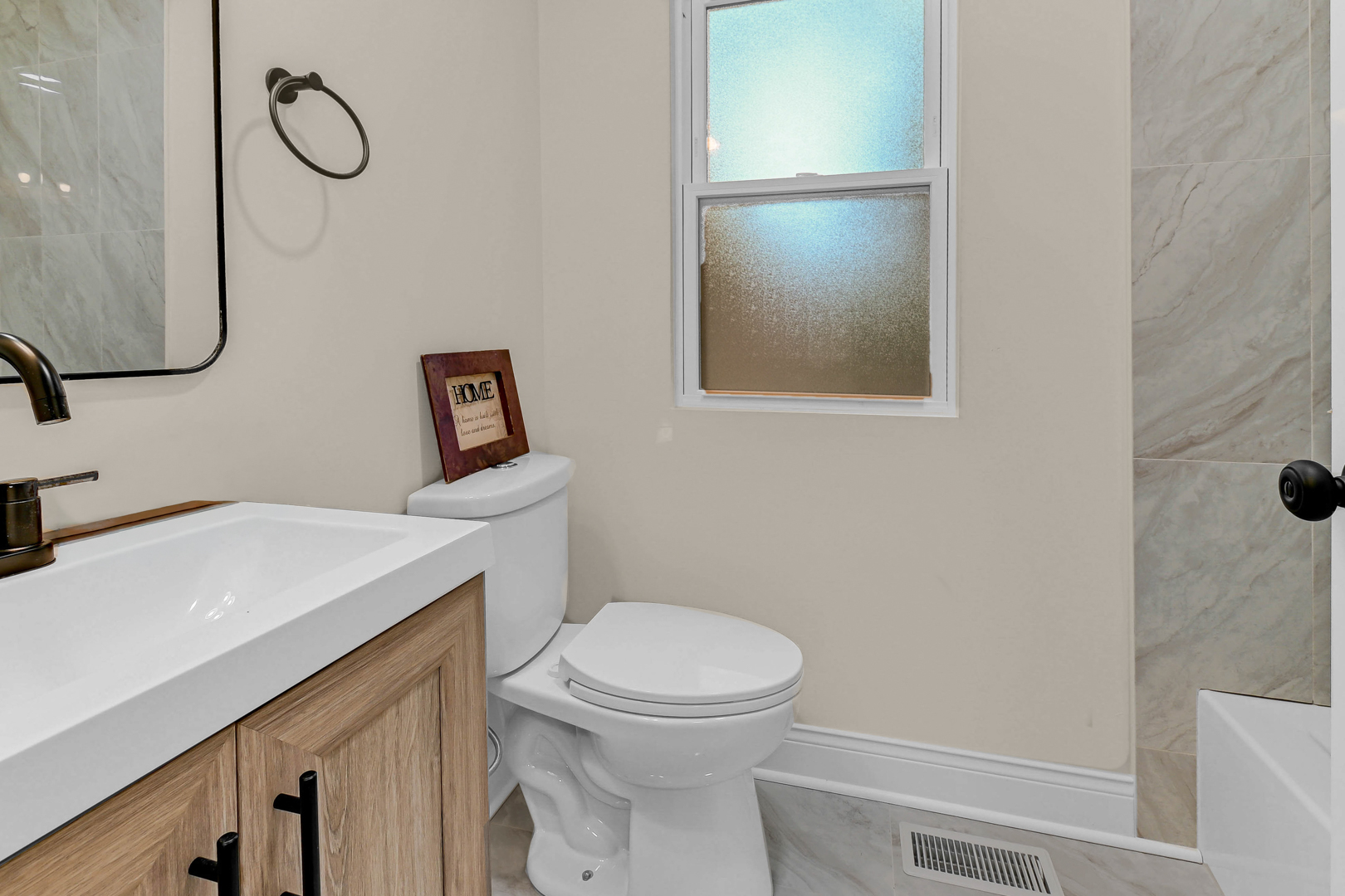 703 West 129th Place Chicago, IL 60628 - Photo 26 of 29 a bathroom with a toilet sink vanity and mirror
