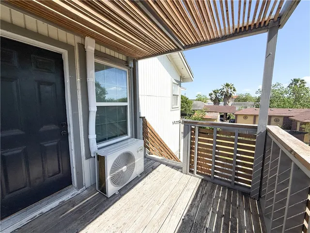 a view of a balcony with wooden floor and iron stairs