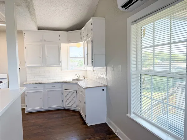 a bathroom with a granite countertop sink mirror and a window