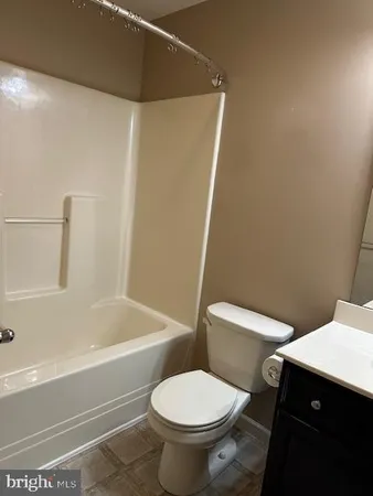a white toilet sitting next to a bath tub