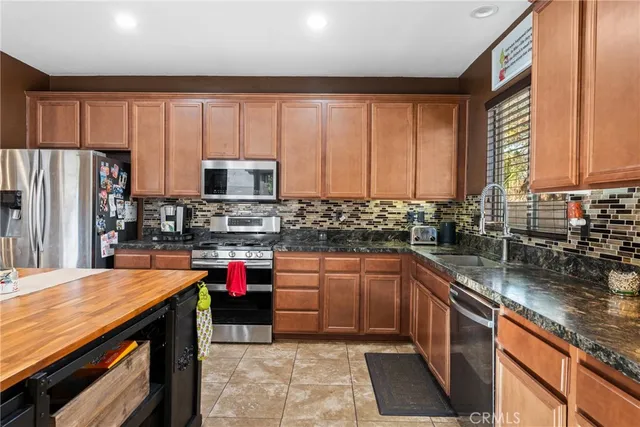 a kitchen with stainless steel appliances wooden cabinets sink and a granite counter top
