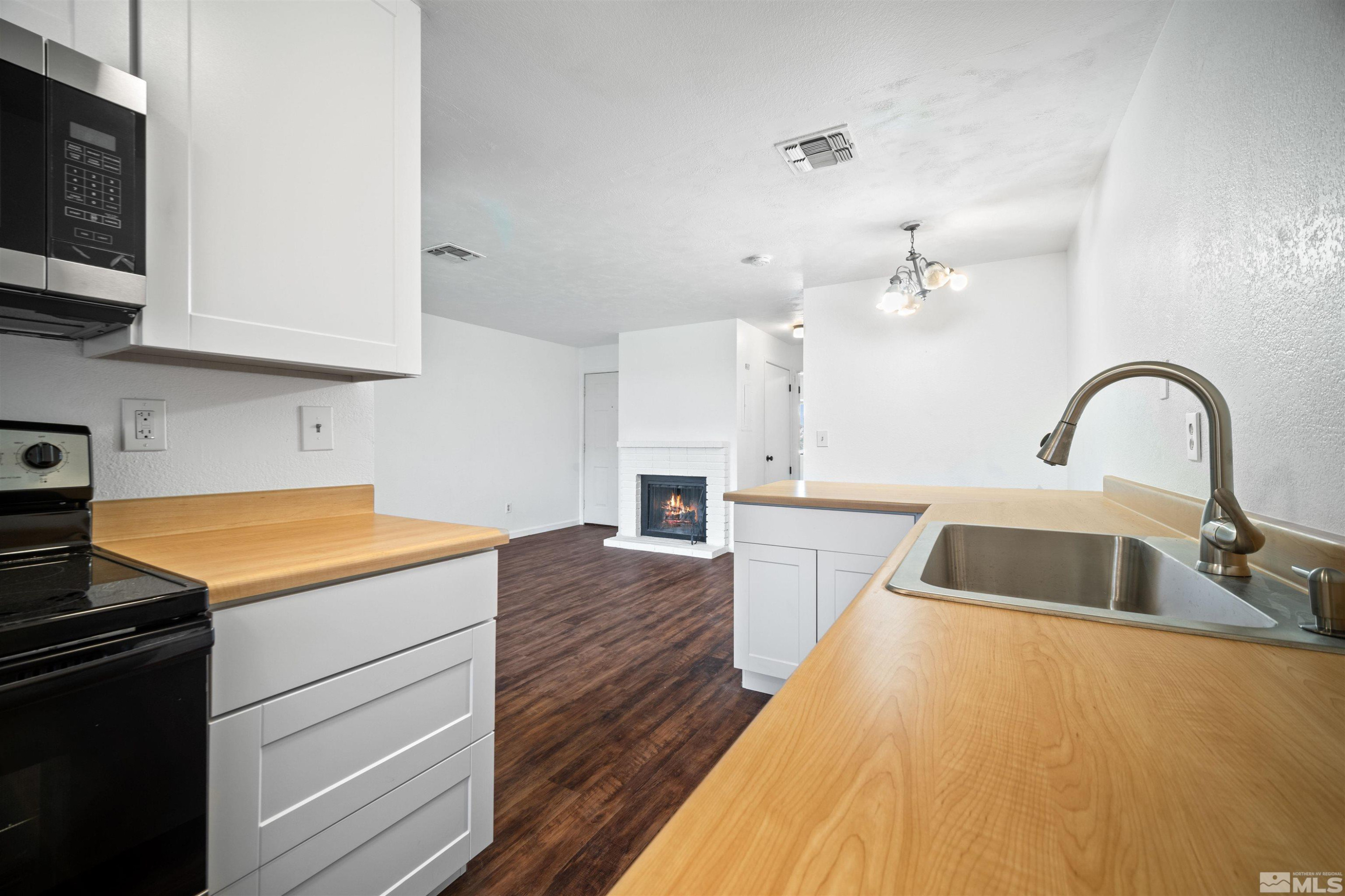 4769 Reggie Road, Unit 254 Reno, NV 89502 - Photo 11 of 23 a kitchen with a sink a stove and cabinets