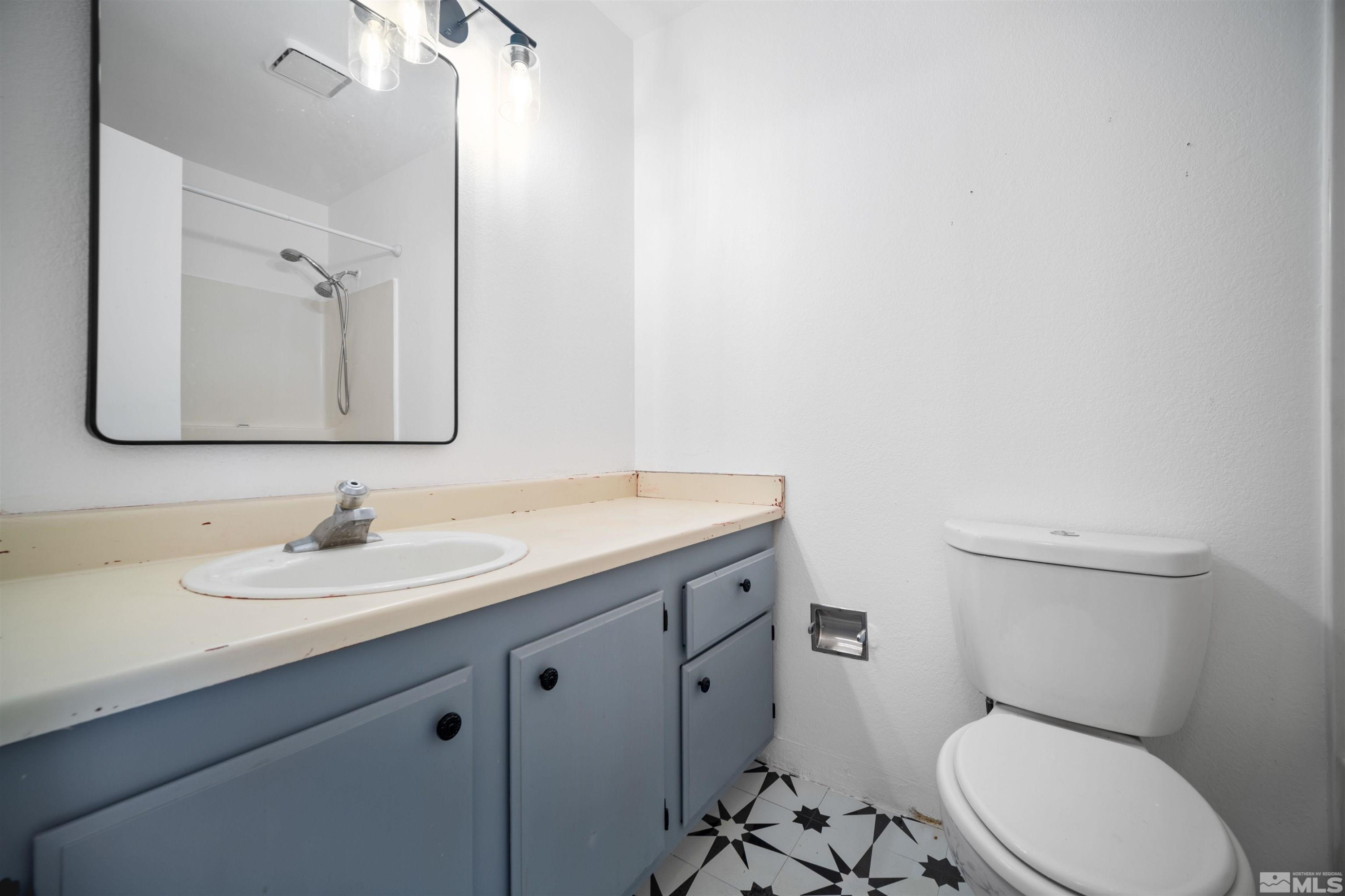 4769 Reggie Road, Unit 254 Reno, NV 89502 - Photo 13 of 23 a bathroom with a toilet a sink and mirror
