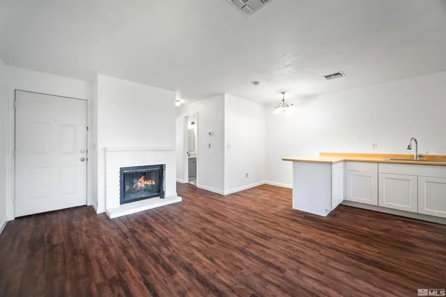 a view of a kitchen with wooden floor and a fireplace